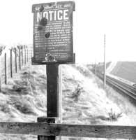 An old and battered North British Railway Company notice concerning bridge traffic, issued under the Locomotive Act of 1861... <I>'An act for regulating the use of locomotives on turnpike and other roads, and the tolls to be levied on such locomotives and on the waggons or carriages drawn or propelled by the same.'</I> The sign is thought to have stood alongside bridge 142 on the Waverley route south of St Boswells, and is seen here looking towards bridge 144, Longnewton. (John Conacher served as NBR GM between 1891-1899). [Ref query 8096] <br><br>[Dougie Squance (Courtesy Bruce McCartney) //]