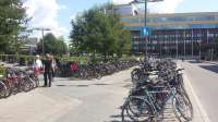 The south side of the station concourse is also full of bicycles. Whereas the Utrecht 12,500 space bicycle park is planned to be underground, in Uppsala the car park is underground and the bike park is green and seen all year round [see image 56273]. The integrated bus station is also visible behind the trees; a yellow bus is just visible to the right of the trees in the centreground.<br><br>[Charlie Niven 25/07/2016]