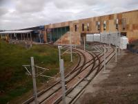 A look at work at Edinburgh Gateway interchange on 01/09/2016. The soon-to-be tramstop (left) now has an overall roof. The other lines are access to Gogar Depot. Unfortunately the rather attractive wooden covering is only a backing to the metal facing currently being applied!<br><br>[David Panton 01/09/2016]