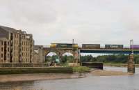 <I>Would suit railway enthusiast</I>. A top floor flat of the warehouse overlooking Carlisle Bridge at Lancaster appears to have a For Sale sign on the balcony. A Freightliner Class 70 passes with the delayed Coatbridge Daventry containers on 1st September 2016, one of over 200 trains that this bridge carries every day.    <br><br>[Mark Bartlett 01/09/2016]