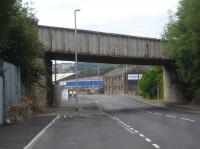 Shortly after passing Headfield Junction the branch line to Dewsbury Railway Street Goods Yard crossed three bridges in close proximity, with Mill Street East overbridge, seen here looking south east, lying between that over the Dewsbury branch of the Calder & Hebble Navigation Canal and that across the River Calder. The branch line is still extant over most of its length although the goods yard and surrounding area is now mostly retail and warehousing. In the early 1970s, shortly after passing out as an Electricity Board electrician, I was based at the depot to left, regularly seeing some of the daily workings to the goods yard; but, regrettably, never taking any photographs.<br><br>[David Pesterfield 22/07/2016]