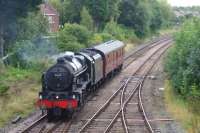 Carrying out a turning move at Lostock Hall Jct, ex LMS 4-6-0 no.46115 'Scots Guardsman' reverses off the line from Farington Jct and briefly heads east towards Bamber Bridge. A few minutes later it came back through the crossover and headed to Preston station to pick up the CME railtour to Carlisle. 50 years ago this movement could have been completed without the need of a reversal with the use of the East Lancs line from Preston via Todd Lane Jct which used to join this line in the dark trees beyond the support coach to the left. It was used then to get holiday specials from Scotland to Blackpool without the need to reverse in Preston.<br><br>[John McIntyre 03/09/2016]