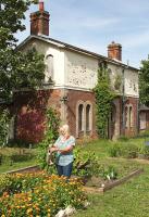 In 2016, members of the local community in Alresford, Essex were engaged in a campaign to save their historic station building from demolition by Abellio Greater Anglia. Part of that campaign involved making the premises look as attractive as possible to show the potential for renovation and community reuse. The building is shown here on 7th July 2016, along with a dedicated local resident tending flower beds added by volunteers. <br><br>[Mark Dufton 07/07/2016]