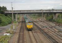 Freightliner 66605 takes a long rake of bright green open wagons along the Up Slow line at Farington Junction on 6th September 2016. This was a working from Hardendale Quarry at Shap to Guide Bridge CE sidings. The deviation of the fast lines behind the train marks the site of Farington station, closed in 1960. <br><br>[Mark Bartlett 06/09/2016]