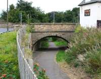 In 1849 the NB opened a short freight-only branch from the ECML east of Prestonpans running south to Tranent, serving various coal workings in the area. The line eventually closed in 1958 and part of the route within Tranent itself is now a walkway. View is north along the old trackbed towards the ECML on 18 September 2016, with the site of the former goods depot behind the camera alongside Elphinstone Road, an area now occupied by commercial premises. Ahead is the bridge carrying the busy A199, below which the line passed to reach its destination, with the hostelry on the right appropriately carrying the name 'The Brig Inn'.  <br><br>[John Furnevel 18/09/2016]