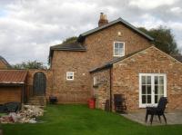 A view of the west end of the former Myton Gate House, with a more recent extension added since closure of the line between Pilmoor and Boroughbridge. The track ran to the right of view, with the level crossing over Ellerthorpe Lane just beyond the house. Other than the extension the structure of the house is much as it was in operational times. <br><br>[David Pesterfield 23/09/2016]