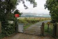 The entrance to Dovey Junction station isn't all it seems, as the actual platforms are over half a mile from this gate. The path runs alongside the Aberystwyth line. In the distance the Pwihelli line bridge over the River Dovey can be seen and the station lies just to the east (right) of this. This location might be more accurately described as Glandyfi as it is close to the site of that closed station and the long path to the previously inaccessible Dovey Junction is a recent innovation. <br><br>[Mark Bartlett 18/09/2016]