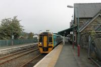 A Sunday morning service for Aberystwyth waits for departure time in the Down platform at Machynlleth. Unit 158832 has just come off the adjacent depot to start its diagram for the day. The Corris Railway narrow gauge station was just behind and below the Up platform but the site is now occupied by a business park, which can just be seen over the fence.<br><br>[Mark Bartlett 18/09/2016]