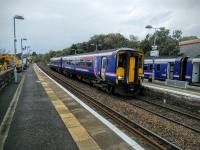 A Kilmarnock to Glasgow service departs its last stop, Barrhead, on 15/10/2016 while a stopper waits in the bay. The person who invents the Gaelic name on the signs seems to have boobed here as Cnoc a' Bharra translates as Barrhill, which is somewhere else. If anything shouldn't it be Ard na Bharra?<br><br>[David Panton 15/10/2016]