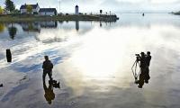 Extreme Railway Photography.In the hope of getting a reflection shot, three photographers stand in the cold waters of Loch Linnhe, at Corpach, awaiting the *The Jacobite * steam train hauled by K1 No.62005.<br><br>[John Gray 21/10/2016]