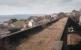 Looking west over Largo Viaduct in 1984 with the station site behind the camera and the chimney of Methil Power Station on the horizon.  A couple of sleepers remain in place.<br><br>[Bill Roberton //1984]