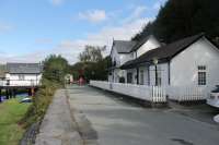 The closed station site at Penmaenpool, looking east towards Dolgellau along the old trackbed in September 2016. The station house is now an accommodation annexe for the adjacent George III Hotel, while the (now removed) platforms were just beyond. The toll house for the estuary bridge is on the left of the picture and the surviving signal box is just hidden behind the small tree. [See image 13937]  <br><br>[Mark Bartlett 19/09/2016]