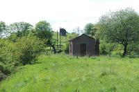 View west from the trackbed looking towards Strathaven Central from the former approach from Stonehouse. On the hillside above the lineside hut is the remains of the viaduct which brought the approach from Strathaven North to Strathaven Central.<br><br>[Ewan Crawford 25/05/2005]