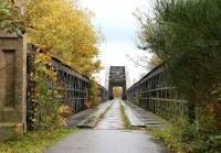 Approaching the Spey Viaduct from the west in October 2005. Located just east of Garmouth on the GNSR Moray Coast line, the viaduct spanned a wide section of the River Spey close to its mouth. The large structure consists of a central bowstring span of 386 ft, with three 107 ft lattice girder spans on either side forming the approaches [see image 5789]. Opened in 1884, the railway route across the viaduct finally closed in 1968 and now forms part of the Speyside Way.<br><br>[John Furnevel 30/10/2005]