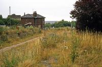 Glemsford station closed in March 1967 along with the rest of the Stour Valley line between Sudbury and Great Shelford. This is the view some 10 years later from the platform, looking east towards the former station house and level crossing.<br><br>[Mark Dufton 07/08/1977]