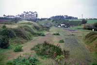 Mundesley on Sea station and yard lay immediately to the south of Links Road in the town, but 12 years after closure, the site had been claimed by housing. This is the view north from Links Road on 2nd May 1976 showing how the track once continued beyond the station towards Trimingham and Overstrand. The lonely building on the horizon was built as a hotel for all the wealthy Victorian and Edwardian holidaymakers that were confidently expected to flock to Mundesley by rail as they had to Cromer. Unfortunately for the ambitions of the railway companies and promoters, the well heeled were not so inclined.<br><br>[Mark Dufton 02/05/1976]