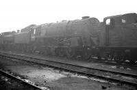 BR Standard class 9F 2-10-0 92207 stands alongside ex-GW locomotives in the yard of its home shed at Southall on a dull and overcast day in the early 1960s.<br><br>[K A Gray //]