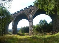Built in 1862 to carry the Border Counties Railway over the Deadwater Burn and surrounding marshland, Kielder Viaduct is considered to be one of the finest surviving examples of Victorian engineering using the skew-arch method of construction. The viaduct is seen here looking south towards Kielder Reservoir in September 2003. Attached to the viaduct directly ahead is a plaque commemorating the work of Peter Nicholson of Newcastle, a pioneer geometrician involved in perfecting the technique.<br><br>[John Furnevel 21/09/2003]