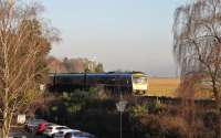 TPE 185130, on a Northern service from Lancaster to Barrow-in-Furness, heads towards the afternoon sun as it runs alongside the promenade at Grange-over-Sands on 28th December 2016. <br><br>[Mark Bartlett 28/12/2016]