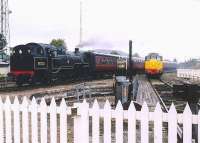 The Strathspey Railway turntable stands in the foreground in this view north at Aviemore in September 2004 with Brush Type 2 31327 (D5862) stabled just beyond. The SRS station and footbridge are visible in the right background. On the left BR Standard tank 80105 is approaching its destination with a morning train from Broomhill.  <br><br>[John Furnevel 25/09/2004]