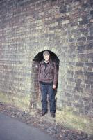 On 2nd April 2010, David Spaven samples one of the refuges for permanent way men set into the brick retaining wall opposite Ladhope Vale in Galashiels. [See image 57716]. This imposing piece of infrastructure was built by the North British Railway following a major landslip in 1916, and is one of his abiding memories from his last journey on the Waverley Route on 2nd January 1969. (Photo by Simon Longland)<br><br>[David Spaven Collection 02/04/2010]