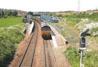 The route is set for down sidings as a Hunterston - Longannet coal train runs slowly through Dunfermline's Queen Margaret station in June 2006 just before entering Halbeath sidings. The train is about to run through the site of Townhill Junction, with the trackbed of the S&D route from Alloa and Stirling on the right. After entering the sidings EWS 66207 will run round its train before heading back to Charlestown Junction where it will take the Kincardine line. [See image 9821] <br><br>[John Furnevel 13/06/2006]