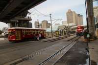 New Orleans street car No 462 departing St Julia station on the Riverfront line as loco No 1505 of the New Orleans Public Belt Railroad brings a freight train along the Mississippi riverfront towards the dock area.<br><br>[Alastair McLellan 09/11/2016]