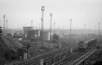 Alongside Millerhill Depot at the north end of Millerhill Yard in 1976 a class 40 pauses with a train of presflos. In the background, beyond the MPD and up yard, a number of large piles of lifted track panels can be seen. The depot was demolished in 2016.<br><br>[Bill Roberton //1976]