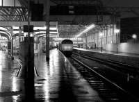 Late evening view along the west side suburban platforms at Kings Cross in December 1980 as a 'Peak' type 4 prepares to leave with a parcels train.<br><br>[John Furnevel 05/12/1980]