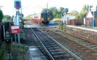 An SPT liveried class 156 DMU runs into Kingsnowe station with a Glasgow Central - Edinburgh Waverley service in October 2002. Note the level crossing barrier activation button mounted on the post on the far left, for use by drivers of westbound stopping trains.<br><br>[John Furnevel /10/2002]