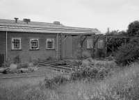 The north east corner of Townhill Wagon Shops after closure. The steelwork may have been used for transhipment of materials by means of lifting tackle, from the siding alongside the works and through the sliding doors. The short lengths of track would hold wheelsets. Thanks to Robert Blane for the suggestion. 1986.<br><br>[Bill Roberton //1986]