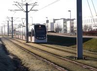 A cold and misty January morning on Edinburgh's west side, where a hard overnight frost has left the grassy shoulders of the tramway with a strangely satisfying 'crunch' underfoot. The tram pictured has just left Edinburgh Park Central and is running alongside the numerous office blocks that line this section of the route on its way to Gyle Centre.   <br><br>[John Furnevel 26/01/2017]