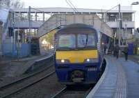 A Dalmuir - Larkhall service waiting to depart sits under the old footbridge with its replacement, now almost complete, seen behind. The new structure, built under the 'Access for All' programme will feature lifts. <br><br>[Colin McDonald 27/01/2017]