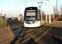 A city bound tram crosses the dual carriageway shortly after leaving  Gyle Centre on 26 January 2017.<br><br>[John Furnevel 26/01/2017]