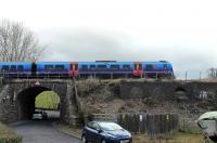 TPE 185120 leaves Windermere with a Northern service for Oxenholme on 12th February 2017. The train is crossing Thwaites Lane. Recent tree clearance has revealed the brick base of the old mechanical signal box [See image 24108], closed when the line was singled. [Ref query 759]<br><br>[Mark Bartlett 12/02/2017]