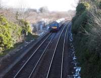 A Glasgow Queen Street – Edinburgh Waverley service runs east through the remains of the E&G's Ratho station (closed 1951) following a fall of snow in March 2006. Beyond the fence stood Ratho Low Level station, from which a line ran to Dalmeny South Junction via Kirkliston. This line lost its passenger service in 1930, although continued in use for freight traffic until 1966. The old station area and yard later became a works site for the Airdrie – Bathgate project, completed in 2010 [see image 21593].    <br><br>[John Furnevel /03/2006]