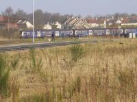 Standing on the site of Broomhouse station, there is still plenty of rail traffic still to be seen - but in the distance on the Rutherglen and Coatbridge line. A passing Class 320 EMU bound for Dalmuir accelerates towards Mount Vernon.<br><br>[Colin McDonald 14/02/2017]