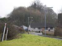 View from the point where the line of the trackbed crosses the B7001 towards the site of Uddingston West station. The solum is intact but much overgrown for a distance from the point where the trees appear behind the house.<br><br>[Colin McDonald 15/02/2017]