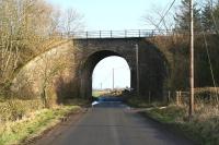 The bridge that once carried the Waverley route over an unclassified road, one and a half miles south of Newtown St Boswells, seen here looking east in February 2017. The wooden platforms of Charlesfield Halt were constructed here in 1942, for the benefit of workers at the nearby munitions depot (now an industrial estate) visible in the background. Access to each platform was via steep pathways on the south side of the bridge to the right. The path nearest, serving the down platform, has been widened since closure to enable access for farm vehicles.<br><br>[John Furnevel 14/02/2017]