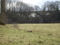 A short distance to the west of Kirbymoorside the line from Pickering to Helmsley and Gilling East ran across an impressive 3 arch viaduct over farmland and the Hodge Beck, and, as this 2017 view looking south towards the A170 trunk road shows, the tall viaduct still stands proud at the end of a long section of extant embankment running from the former level crossing on Starfitt Lane to left of view.<br><br>[David Pesterfield 01/03/2017]