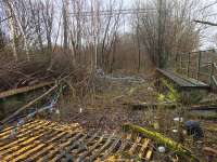 View of the trackbed on the bridge across Gartocher Road taken through the fence at the Network Rail Shettleston Depot. At this point the line had three tracks with sidings on the left after crossing the bridge. A OHLE stanchion, dating back to the days when the stub of the line formed part of the Shettleston depot, can still be seen through the trees. [See image 35603]. Access with permission.  <br><br>[Colin McDonald 17/03/2017]