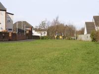 View north west along the trackbed approaching the site of Uddingston East, which was just beyond the roundabout in the distance (itself formerly the site of a roadbridge). To the left, a school building, much modernised, survives from the days of the railway.<br><br>[Colin McDonald 24/02/2017]