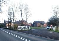 Looking  south across the A6108 in the summer of 2011 towards the site of the  former Masham station and goods yard, now in use as a camping and caravan park. The  crossing gates were installed in 1905 when a siding was extended across the road to serve a contractor's  transhipment yard with 2ft gauge tramway used in the construction of two nearby reservoirs.  Masham station served its last passengers in January 1931, with the line from Melmerby Junction closing completely in 1963. [See image 34893] <br><br>[John Furnevel 27/06/2011]