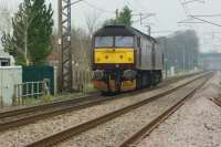 A pair of WCRC Brush Type 4s head north along the WCML at Brock on 18 February 2017 whilst on a light engine move back to Carnforth. The photo is taken through palisade fencing near to the River Brock with the site of the old foot crossing and station this side of the rear locomotive.<br><br>[John McIntyre 18/02/2017]