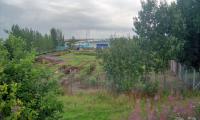 View north over the site of the former North British station at Bellshill in 2000. After closure the trackbed was landscaped. Following a re-alignment of the A721 the land became vacant which re-opened up this view of the site. The distant Securicor Omega depot (now a Yodel depot) is by the site of the junction, just north of the station, for Hattonrig Colliery. The site of the station has subsequently been redeveloped.<br><br>[Ewan Crawford //2000]