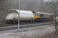 A gap in the trees alongside the B6265 road allows this snap of GBRf 66714 with the leading wagon of a train it has just brought to Rylstone from Hull. The wagon was deposited here (for maintenance?) while the resident shunter took the rest of the train forward for loading. <br><br>[Mark Bartlett 28/03/2017]