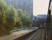 A view to the rear of a diverted Birmingham train passing under the footbridge at Morningside Road station in July 1989. Another passenger train is just visible disappearing under Morningside Road  OB11 as a bus passes over it.<br><br>[Charlie Niven /07/1989]