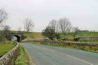 Disused section of the Grassington branch trackbed, just outside the site of the station [See image 33917], which is itself now built over. The three arch over bridge high up on the right is a notable survivor. The line only opened in 1902 and scheduled passenger services ceased in 1930 but complete closure of this section only came in 1969 and the line south of Rylstone still sees several stone trains each day.  <br><br>[Mark Bartlett 28/03/2017]