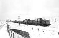 Snowy conditions at Whitrope on Sunday 30 November 1969, with Claytons 8586+8610 having paused and a crew member about to enter the cab of the second locomotive. The 50 wagons were being propelled south from Hawick to Newcastleton to be used for the collection of concrete sleepers following track recovery.  <br><br>[Bruce McCartney 30/11/1969]