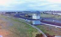 Barassie Junction and Signalbox looking southwest from the road bridge approach, 23 August, 1982. At the time, preparations were underway behind the 'box for the deviation of the line to ease the curve onto the line to Troon station, this connected up after the Troon avoiding line formally closed on Saturday, 27 November, 1982. The old Kilmarnock & Troon Railway alignment that formerly ran round to the harbour from Barassie Junction had been cut back to become dead-end sidings, circa 1973, when the harbour sidings were lifted,  these sidings still in use in August, 1982 and visible behind the Signalbox, with what appeared to be a rail-mounted crane standing in the headshunt. There had been three more dead-end sidings on the west side of the Signalbox (on the original alignment of the K&TR), but these had been lifted after Barassie Works closed in (I believe) 1972.<br><br>[Robert Blane 23/08/1982]